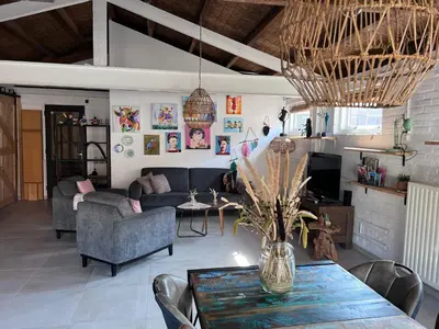 a living room with a couch and a table at Finca Noordwijk met privé tuin, dichtbij strand in Noordwijk