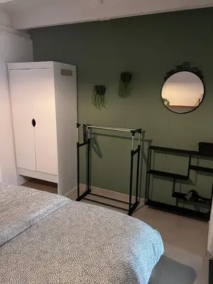 a bedroom with a bed and a mirror on the wall at Finca Noordwijk met privé tuin, dichtbij strand in Noordwijk