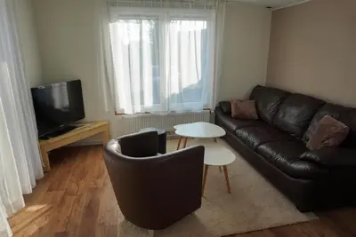 a living room with a couch and a tv and a table at Modern chalet at holiday park in Opmeer near Amsterdam in Opmeer
