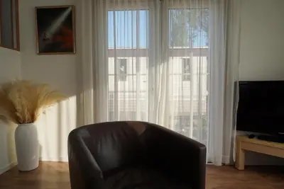 a leather chair sitting in front of a large window at Modern chalet at holiday park in Opmeer near Amsterdam in Opmeer