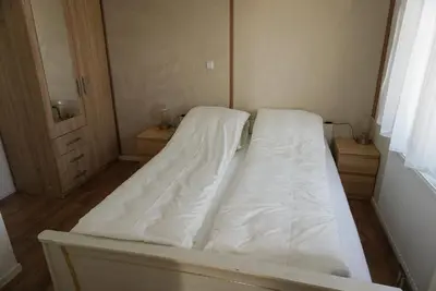 a bed in a room with white sheets on it at Modern chalet at holiday park in Opmeer near Amsterdam in Opmeer