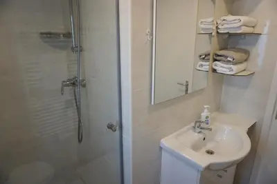 a bathroom with a shower and a sink and a mirror at Modern chalet at holiday park in Opmeer near Amsterdam in Opmeer