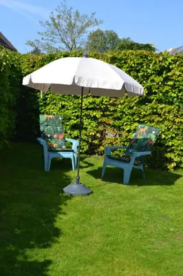 two chairs and an umbrella in the grass at Studio 38 in Zandvoort