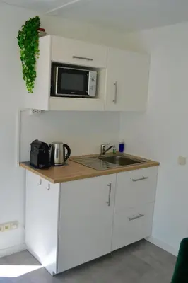 a white kitchen with a sink and a microwave at Studio 38 in Zandvoort