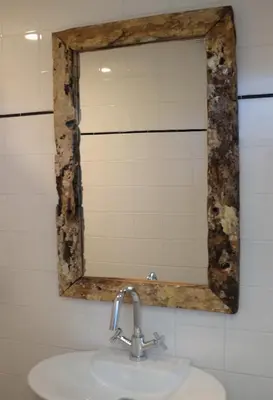 a mirror above a sink in a bathroom at Kuta Beach in Zandvoort