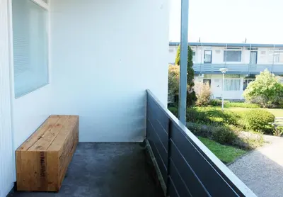 a wooden bench sitting on the side of a building at Kuta Beach in Zandvoort