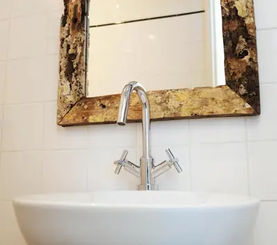 a mirror above a sink in a bathroom at Kuta Beach in Zandvoort