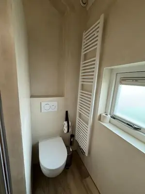 a small bathroom with a toilet and a window at Vakantiehuis aan het water in Vinkeveen