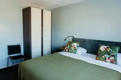 a bedroom with a large bed with two pillows at Appartement Spoorklokken in Bergen aan Zee