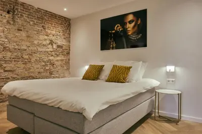 a bedroom with a bed with a brick wall at RITCH Aparthotel Alkmaar in Alkmaar