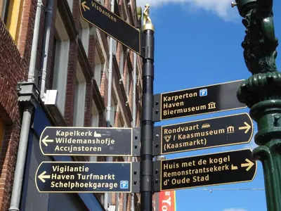 a pole with street signs on it in front of a building at RITCH Aparthotel Alkmaar in Alkmaar
