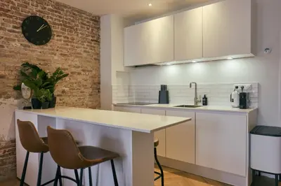 a kitchen with white countertops and a brick wall at RITCH Aparthotel Alkmaar in Alkmaar
