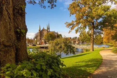 a park with a river in front of a building at RITCH Aparthotel Alkmaar in Alkmaar