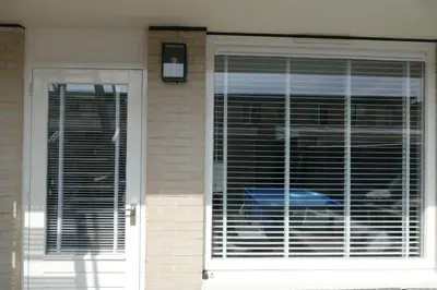 a front door of a house with blinds on it at Studio Noordzee in Zandvoort