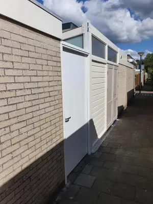 a white door on the side of a brick building at Studio Noordzee in Zandvoort