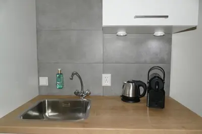 a kitchen counter with a sink and a tea kettle at Studio Noordzee in Zandvoort