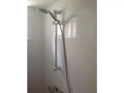 a shower with a shower head in a bathroom at Beach House Arina in Egmond aan Zee