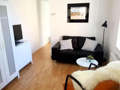 a living room with a black couch and a table at Beach House Arina in Egmond aan Zee