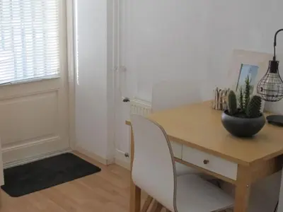 a room with a wooden table with a plant on it at Beach House Arina in Egmond aan Zee