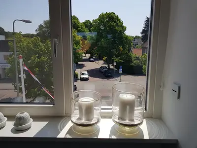 two candles on a window sill with a view of a street at Deluxe STUDIO-appartement Heemstede Zandvoort in Heemstede