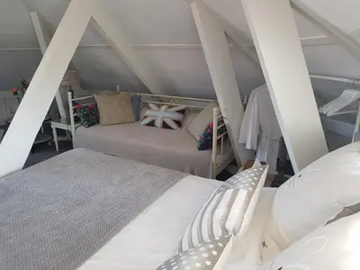 a attic bedroom with two beds in a room at Deluxe STUDIO-appartement Heemstede Zandvoort in Heemstede