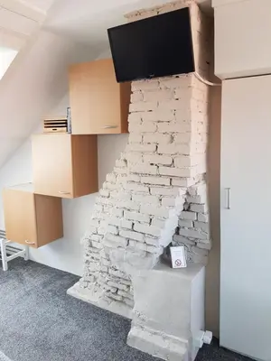 a living room with a brick wall with a tv on it at Deluxe STUDIO-appartement Heemstede Zandvoort in Heemstede