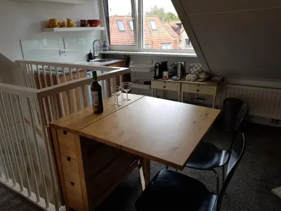 a kitchen with a table with a bottle of wine on it at Deluxe STUDIO-appartement Heemstede Zandvoort in Heemstede