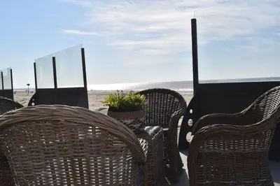 a group of wicker chairs sitting on the beach at STRAND 21 hotelchalets in Zandvoort
