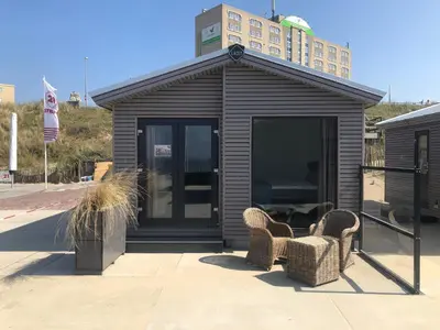 a small black building with two chairs in front of it at STRAND 21 hotelchalets in Zandvoort
