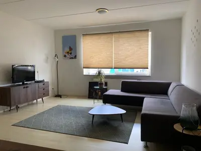 a living room with a couch and a television at Apartments Zaanse Schans and Amsterdam in Wormer