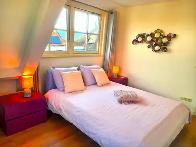 a bedroom with a white bed with a window at Villa Pura Vida in Oud-Ade