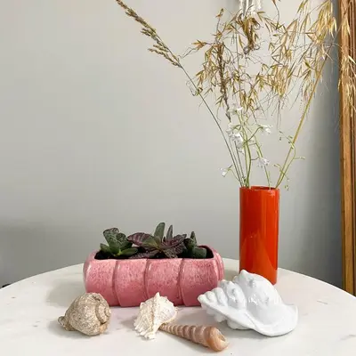 a table with a red vase and some plants at Fabel aan Zee in Zandvoort
