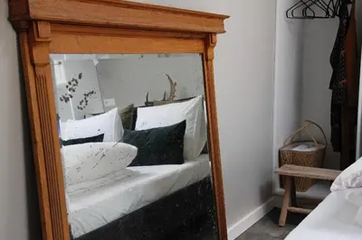 a mirror reflecting a bed with white pillows at Fabel aan Zee in Zandvoort