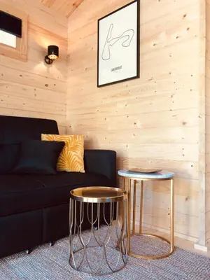 a living room with a black couch and two tables at LODGE 5 Zandvoort in Zandvoort