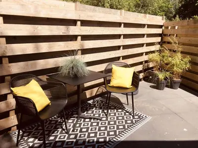 a patio with two chairs and a table with yellow pillows at LODGE 5 Zandvoort in Zandvoort