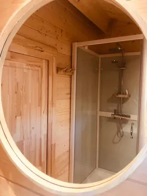 anorthole view of a shower in a wooden room at LODGE 5 Zandvoort in Zandvoort
