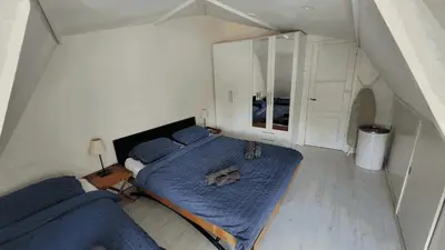 a bedroom with a large blue bed in an attic at Villa Amsteldijck (8km from Amsterdam) in Ouderkerk aan de Amstel