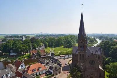 an old church with a steeple in a small town at Villa Amsteldijck (8km from Amsterdam) in Ouderkerk aan de Amstel