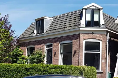 a red brick house with a black roof at Villa Amsteldijck (8km from Amsterdam) in Ouderkerk aan de Amstel