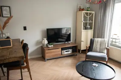 a living room with a television and a table at huisje de Strandjutter in Katwijk aan Zee