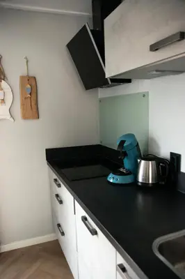 a kitchen with a black counter top and a sink at huisje de Strandjutter in Katwijk aan Zee
