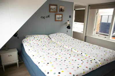 a bed with polka dot sheets in a bedroom at huisje de Strandjutter in Katwijk aan Zee