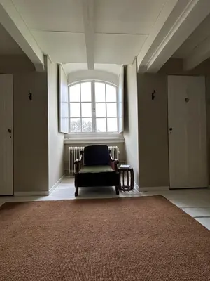 a living room with a chair and a window at Eco Hotel Plantage Rococo in Velsen-Zuid