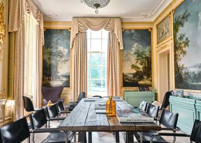 a dining room with a long table and chairs at Eco Hotel Plantage Rococo in Velsen-Zuid