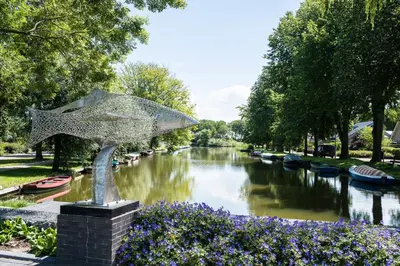 a statue of an umbrella over a river with boats at B&B 't Raethuys in Dirkshorn