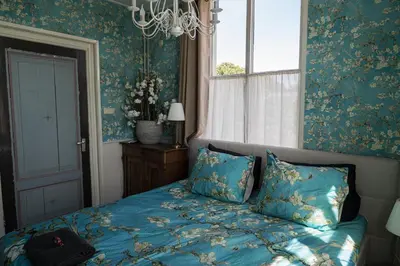 a bed in a bedroom with blue walls and a window at B&B 't Raethuys in Dirkshorn