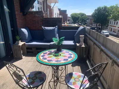 a patio with a table and chairs and a couch at The Rock in Zandvoort