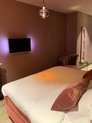 a bedroom with a bed and a flat screen tv at The Rock in Zandvoort
