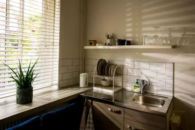 a small kitchen with a sink and a window at Slapen bij Jesse in Broek in Waterland