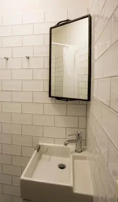 a bathroom with a sink and a mirror and white tiles at Slapen bij Jesse in Broek in Waterland